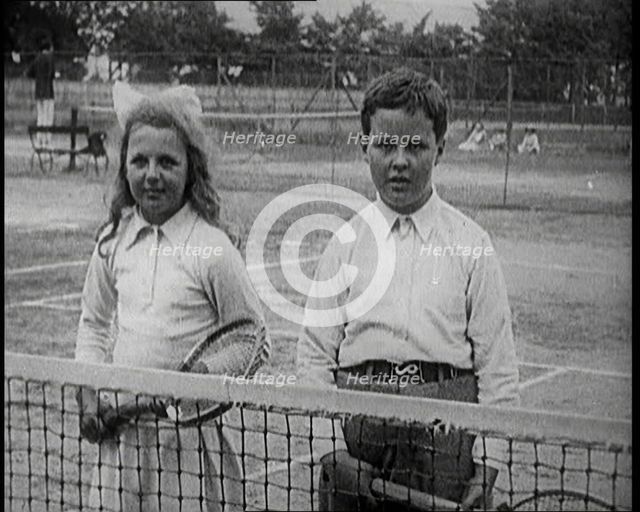 British Tennis Player Betty Nuttall as a Child, Standing on a Tennis Court With a Young Boy, 1921. Creator: British Pathe Ltd.