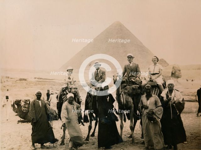 British tourists seated on camels in front of The Great Pyramid, Giza, Egypt, 1936. Artist: Unknown