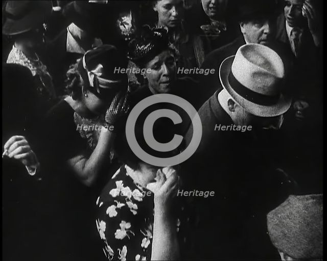 British Women and Men on a Crowded Railway Platform and Several Who Are Looking Upset, 1939. Creator: British Pathe Ltd.