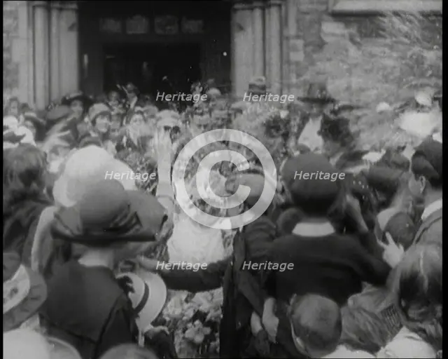 British Bride and Groom Exiting a Church After Their Wedding Ceremony. Guests Are Throwing..., 1921. Creator: British Pathe Ltd.