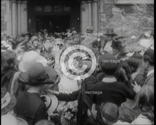 British Bride and Groom Exiting a Church After Their Wedding Ceremony. Guests Are Throwing..., 1921. Creator: British Pathe Ltd.