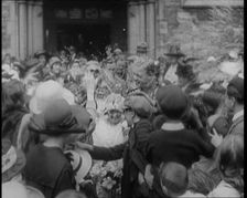 British Bride and Groom Exiting a Church After Their Wedding Ceremony. Guests Are Throwing..., 1921. Creator: British Pathe Ltd