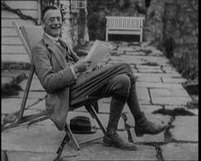 British Chancellor of the Exchequer Joseph Austen Chamberlain Reading a Newspaper While..., 1920. Creator: British Pathe Ltd