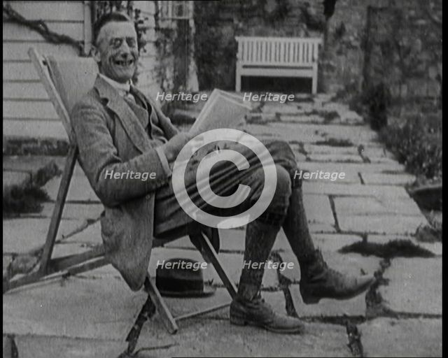 British Chancellor of the Exchequer Joseph Austen Chamberlain Reading a Newspaper While..., 1920. Creator: British Pathe Ltd.