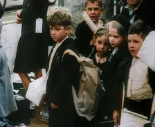 British Child Evacuees Standing on a Pavement With Bags and Boxes as Adults are Standing..., 1939. Creator: British Pathe Ltd