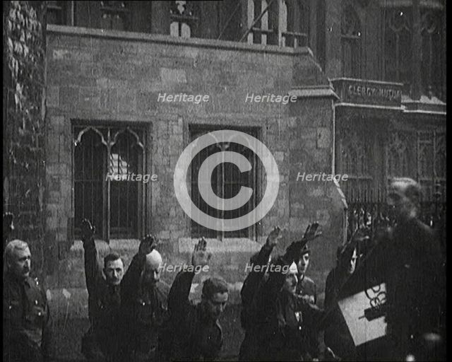 British Fascists Kneeling and Saluting in London. Some Are Carrying Flags, 1922. Creator: British Pathe Ltd.