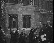 British Fascists Kneeling and Saluting in London. Some Are Carrying Flags, 1922. Creator: British Pathe Ltd