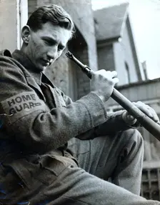 British Home Guard soldier cleaning his rifle, World War II, c1940-c1944. Creator: Unknown