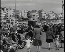 British Holidaymakers Walking Along the Promenade or Sitting on Deckchairs at Brighton..., 1938. Creator: British Pathe Ltd