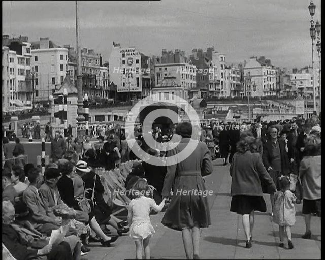 British Holidaymakers Walking Along the Promenade or Sitting on Deckchairs at Brighton..., 1938. Creator: British Pathe Ltd.