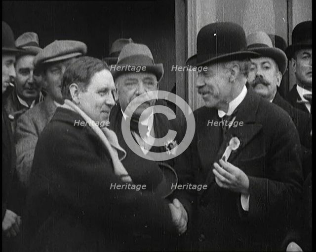 British Man Exiting a Building and Shaking Hands as Part of a by Election Campaign, 1921. Creator: British Pathe Ltd.