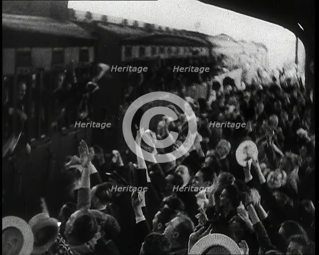 British Men Leaning Out of Railway Carriages and Saying Goodbye to People on a Crowded..., 1939. Creator: British Pathe Ltd.
