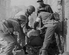 British Medics Helping a Fellow Soldier, 1943-1944. Creator: British Pathe Ltd