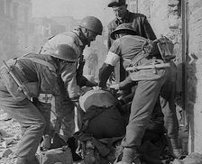 British Medics Helping a Fellow Soldier, 1943-1944. Creator: British Pathe Ltd