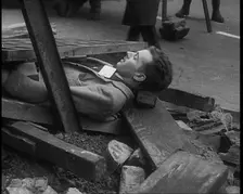 British People Acting Out Bomb attacks and Crashed German Planes, Lying Under Rubble, 1940. Creator: British Pathe Ltd