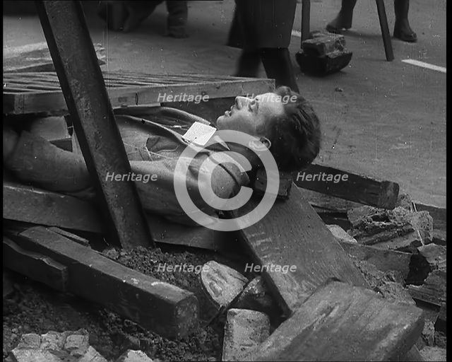 British People Acting Out Bomb attacks and Crashed German Planes, Lying Under Rubble, 1940. Creator: British Pathe Ltd.