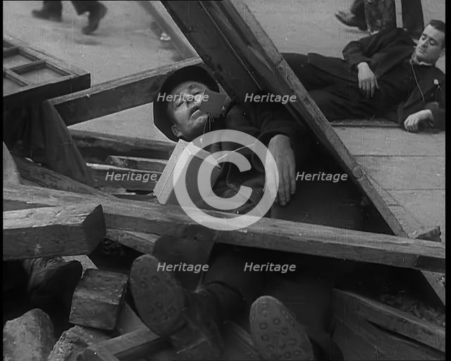 British People Acting Out Bomb attacks and Crashed German Planes, Lying Under Rubble, 1940. Creator: British Pathe Ltd.