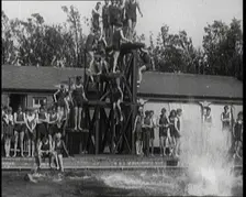 British People Jumping from Various Tiers of Diving Boards at the Chiswick Open Air Baths, 1920. Creator: British Pathe Ltd