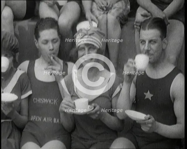 British People Sitting Around and Drinking Cups of Tea While Wearing Bathing Suits at the.., 1920. Creator: British Pathe Ltd.