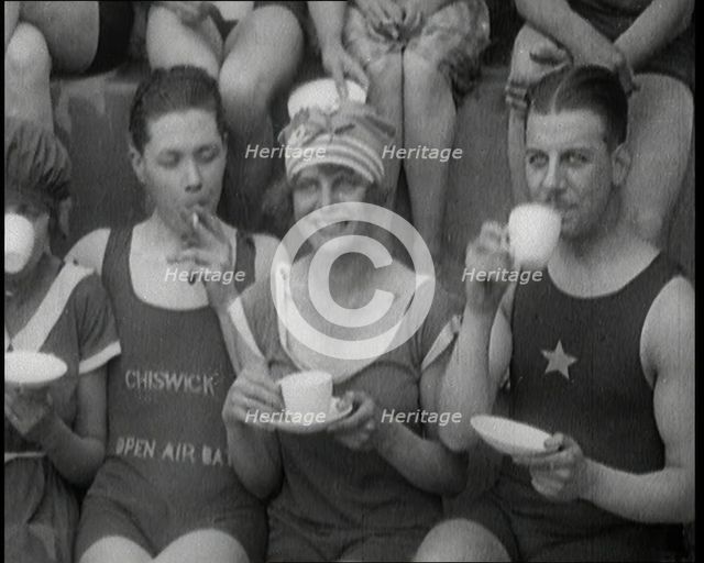 British People Sitting Around and Drinking Cups of Tea While Wearing Bathing Suits at the.., 1920. Creator: British Pathe Ltd.