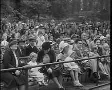 British People Watching Chimpanzees Having a Tea Party at the Zoo, 1940. Creator: British Pathe Ltd