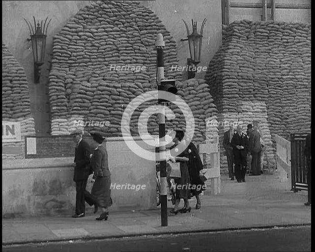 British People Walking by Heavily Sandbagged Buildings, 1940. Creator: British Pathe Ltd.
