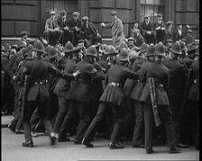 British Police Officers Holding Back Crowds of Demonstrators in Downing Street, London, 1920. Creator: British Pathe Ltd