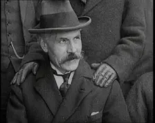 British Prime Minister Ramsay MacDonald Sitting Down. a Pair of Hands Rests on His Shoulders, 1924. Creator: British Pathe Ltd