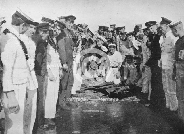 'British sailors round a hole in the deck of their vessel', 1915. Artist: Unknown.