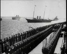 British Sailors Standing to Attention as British Warships Sail Past, 1935. Creator: British Pathe Ltd
