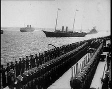 British Sailors Standing to Attention as British Warships Sail Past, 1935. Creator: British Pathe Ltd