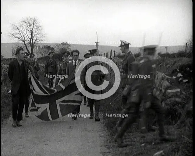 British Soldiers Marching a Sinn Fein Supporter Down a Country Lane, Forcing Him to Bear..., 1920. Creator: British Pathe Ltd.