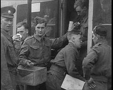 British Soldiers Receiving Food and Drinks on Trains Taking Them To Camp, 1940. Creator: British Pathe Ltd