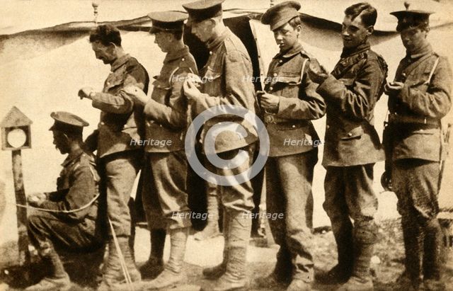 British soldiers synchronising their watches on the front line, First World War, 1914-1918, (1933). Creator: Unknown.