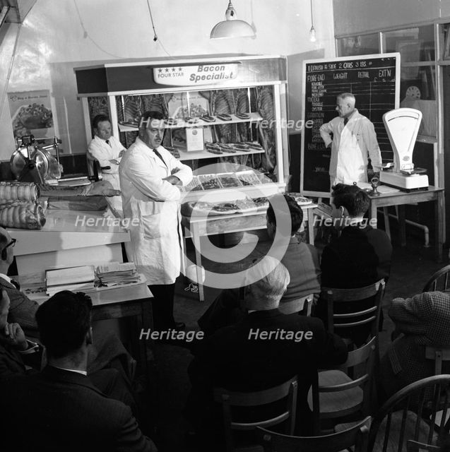Butcher from Danish Bacon giving a demonstration, Kilnhurst, South Yorkshire, 1961.  Creator: Michael Walters.