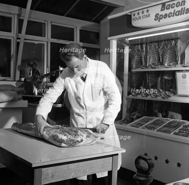 Butcher from Danish Bacon giving a demonstration, Kilnhurst, South Yorkshire, 1961.  Creator: Michael Walters.