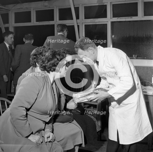 Butcher from Danish Bacon giving a demonstration, Kilnhurst, South Yorkshire, 1961.  Creator: Michael Walters.