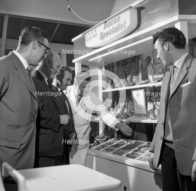 Butcher from Danish Bacon giving a demonstration, Kilnhurst, South Yorkshire, 1961.  Creator: Michael Walters.