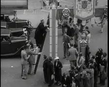 Bud Flanagan With a Frying Pan Climbing a Ladder Resting Against Coronation Decorations in..., 1937. Creator: British Pathe Ltd
