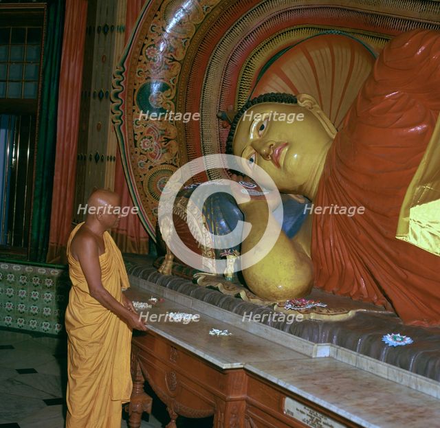 Buddhist priest before the image of a reclining Buddha. Artist: Unknown