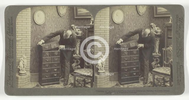 Building up an Underwood Patent Extension Stereograph Cabinet, - in a home Library, 1901. Creator: Underwood & Underwood.