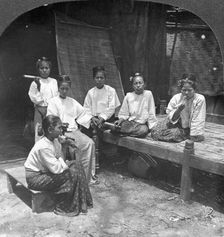 Burmese women smoking outside their home, Mandalay, Burma, 1908. Artist: Stereo Travel Co