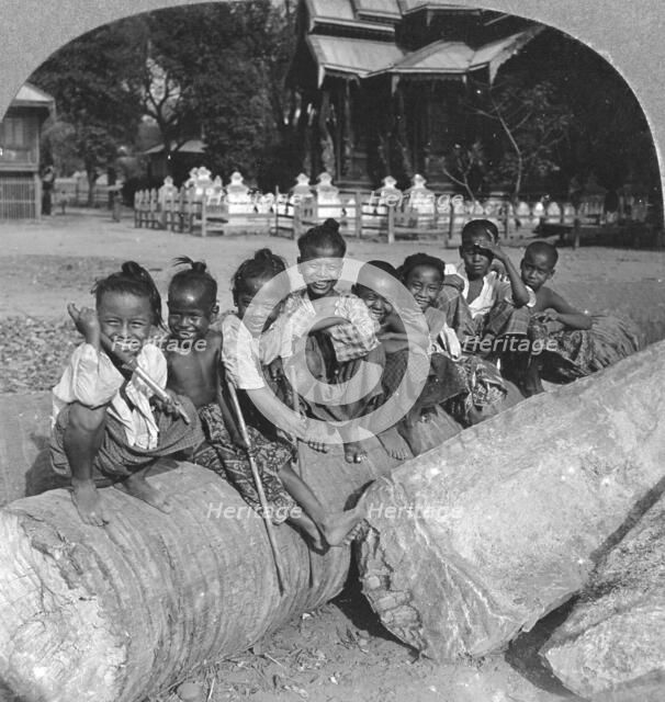 Burmese children sitting on a palm log, Burma, 1908. Artist: Stereo Travel Co