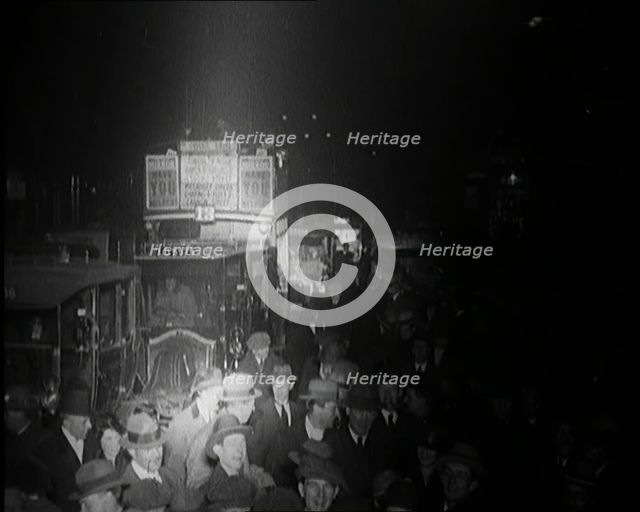 Buses and Crowds of People on a Busy London Street at Night, 1920s. Creator: British Pathe Ltd.