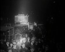 Buses and Crowds of People on a Busy London Street at Night, 1920s. Creator: British Pathe Ltd