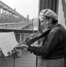 Busker playing the violin, Hungerford Bridge, Lambeth, London, c1946-c1959. Artist: John Gay