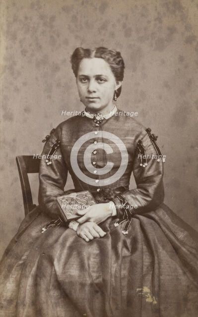Business card, studio portrait of woman holding a photo album. (c1880s) Creator: Karolina Christianson.