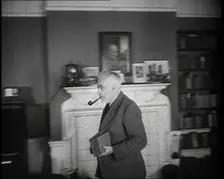 C.E.M Joad Taking Some Books to His Desk, 1930s. Creator: British Pathe Ltd
