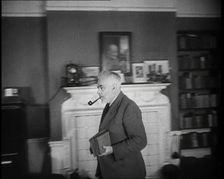C.E.M Joad Taking Some Books to His Desk, 1930s. Creator: British Pathe Ltd