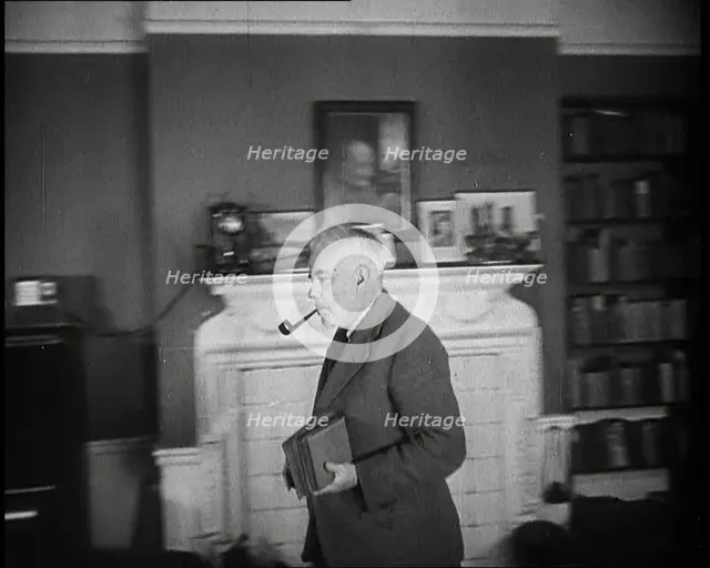 C.E.M Joad Taking Some Books to His Desk, 1930s. Creator: British Pathe Ltd.